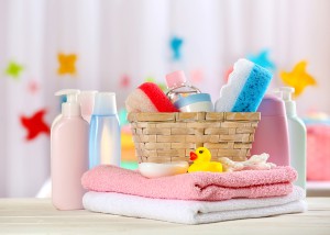 Baby accessories for bathing on table on light background